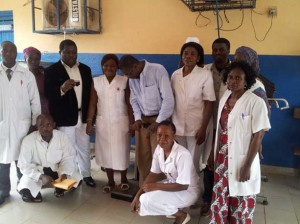 Staff at Ekondo Titi hospital pose with Tata Ati Adolph as he tries the Scale donated to them.