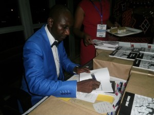 Takwi signs a copy of Breaking The Barracks at the launch