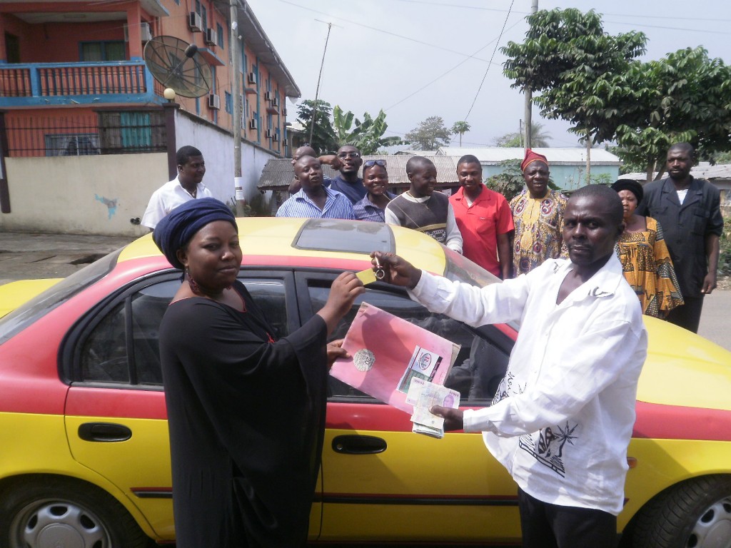 Buea Branch Manager of Raven Green, Asaah (L) hands over car keys & documents to the beneficiary, Gabuin
