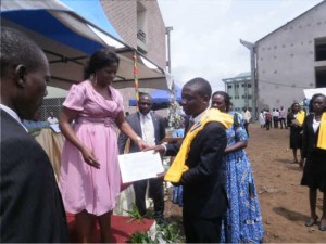 Mrs Nicole Okalia Bilai hands over an attestation & cash prize of FCFA 200,000 to a UB needy student