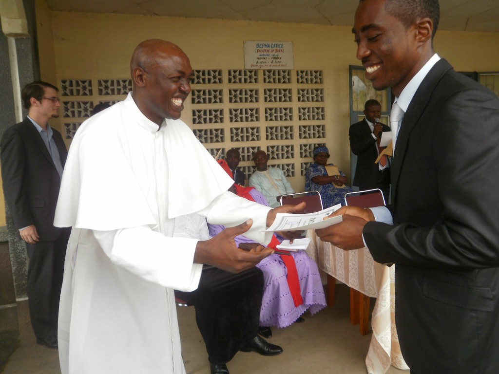 Rev.Fr Nkeze (L) awards a scholarship package to a deserving student of UIDB