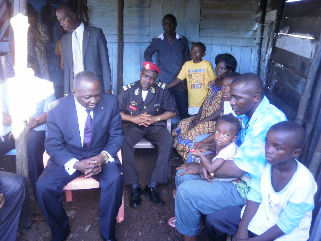 Mr Okalia Bilai(seated in suit) tells a depressing family to take courage after the loss of their loved one