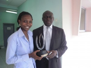 Charline Flore Demgne(L) presents her award to her boss,  David Chuye Bunyui, Director, CRTV Southwest Regional Station