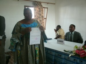 Josephine Ninjo, another beneficiary, brandishes her cheque after signing it out