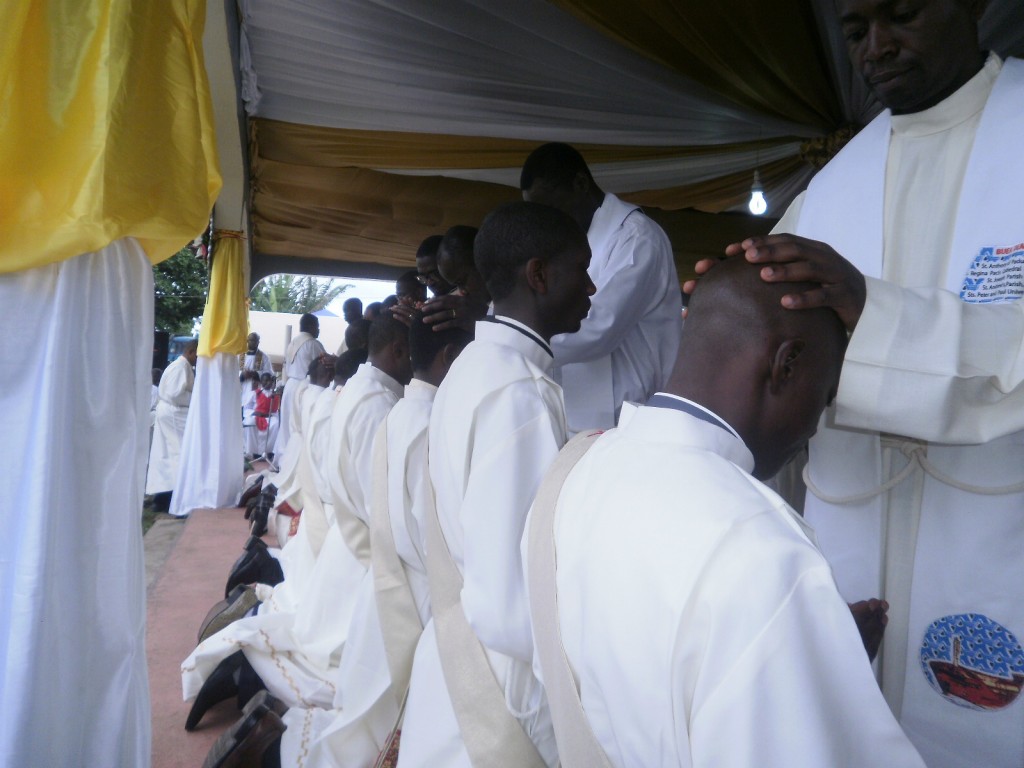 The ordination rite is being executed with the laying of hands on the head of a Deacon