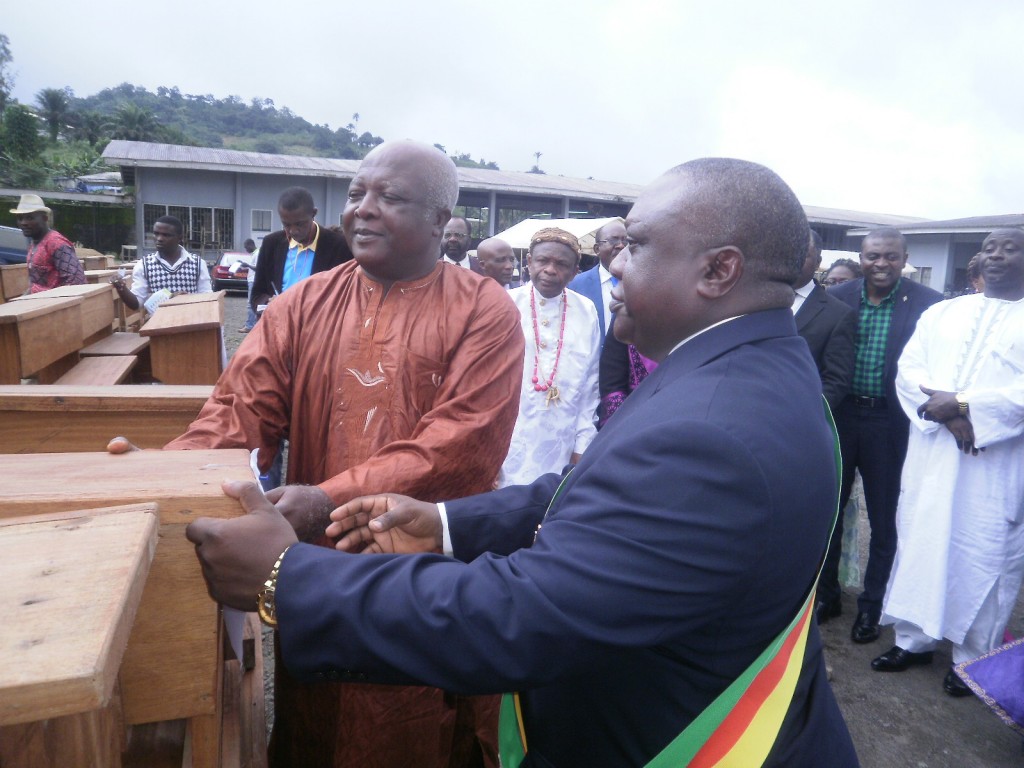 Hon Lisinge(R) symbolically hands a bench to the Fako Divisional Delegate of Basic Education